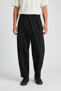 Pantalon jupe-culotte drapé noir porté par un mannequin homme